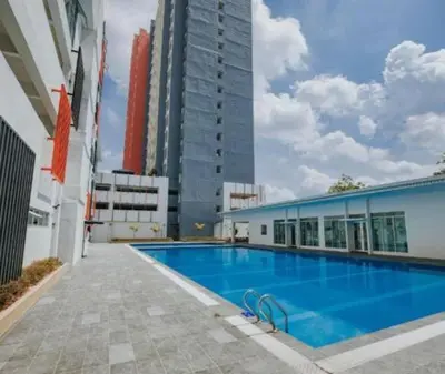 a large swimming pool next to a tall building at Kyra's Downtown Delight in Ipoh