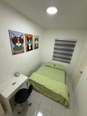a small bedroom with a green bed and a desk at Kyra's Downtown Delight in Ipoh