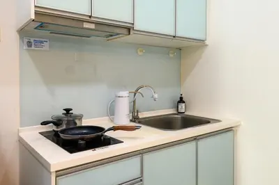 a kitchen with a sink and a frying pan on a stove at 2R2B Lovely Home 1-8pax Gurney Mansion One in George Town