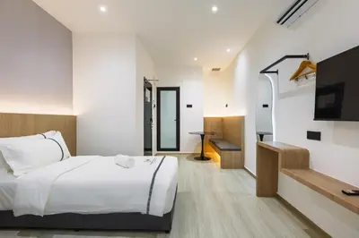 a bedroom with a bed and a flat screen tv at Edenwood Hotel in George Town