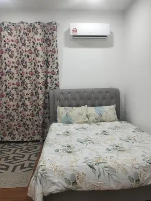 a bedroom with a bed with a flower patterned curtain at Tenang Tambun House in Tanjung Rambutan