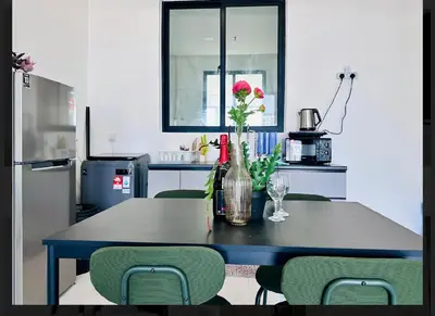 a table with a vase of flowers on it in a kitchen at Spacious 3BR Retreat Comfort & Style in the City 2-10pax in Jelutong