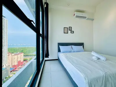 a bedroom with a bed and a large window at Modern 3BR Getaway Perfect for Families & Groups 10 pax in Jelutong
