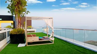 a balcony with green grass and a hammock at Cozy & Chic 3BR Apartment Great Location 2-10pax in Jelutong