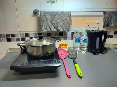 a stove top with a pot and spatula on a counter at Kea Farm Sweet Cozy Resort Copthorne in Brinchang