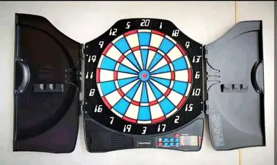 a dart board on a table with two controllers at Perfect for Groups! 2BR with 5 Queen Beds & WiFi in Jelutong