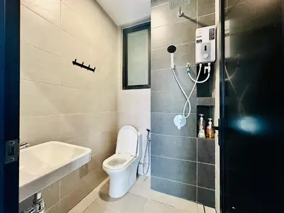 a bathroom with a toilet and a sink at Perfect for Groups! 2BR with 5 Queen Beds & WiFi in Jelutong