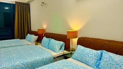 a hotel room with two beds and two lamps at Relax & Unwind 2BR Apartment with 5 Queen Beds in Jelutong