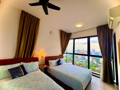 a hotel room with two beds and a window at Relax & Unwind 2BR Apartment with 5 Queen Beds in Jelutong