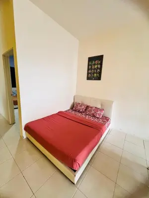 a small bed in a room with a red blanket at Rayyan'Homestay PRIMA in Tanah Rata