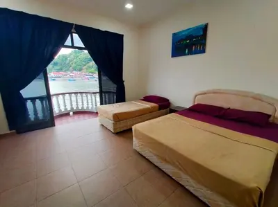 a bedroom with two beds and a view of the water at Capital O 91118 Chalet Seri Idaman in Kampong Batu Maung