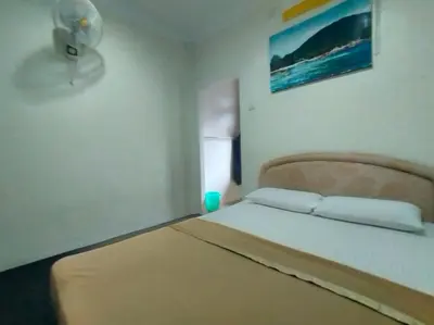 a small bedroom with a bed with a headboard at Capital O 91118 Chalet Seri Idaman in Kampong Batu Maung
