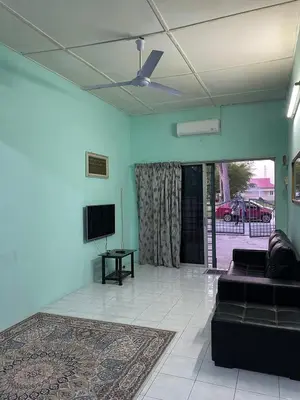 a living room with a couch and a flat screen tv at Teratak Bonda Homestay Seri Iskandar in Seri Iskandar