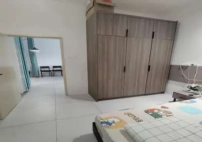 a room with a bedroom with a tub and a wooden cabinet at Cosy Townhouse in Tasek Gelugor in Ara Rendang