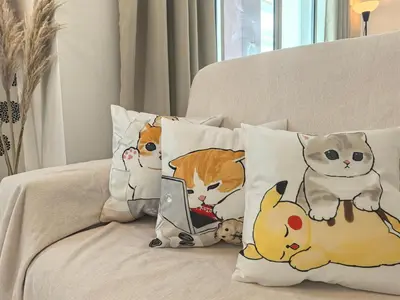 a group of pillows with cats on a couch at Padang Serai Wangi Homestay in Padang Serai