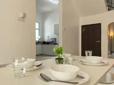 a table with white bowls and glasses on it at Padang Serai Wangi Homestay in Padang Serai