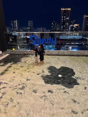 two children standing in the sand on the top of a building at Bright & airy 3BR homestay comfort penang Netflix in George Town