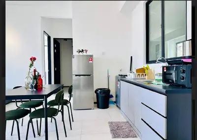 a kitchen with a refrigerator and a table and chairs at Bright & airy 3BR homestay comfort penang Netflix in George Town