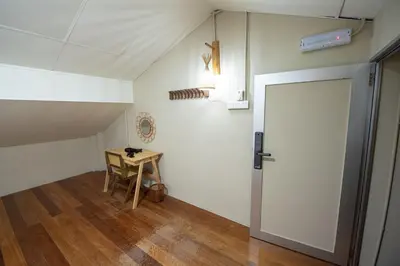 an attic room with a table and a door at DeLuma - Lebuh Melayu 4 Bedroom in George Town