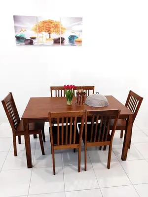 a wooden dining table and chairs with flowers on it at Homestay Bunga Raya Wifi Netflix in Sitiawan