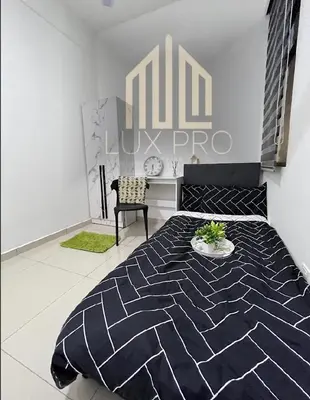 a bedroom with a black and white bed and a chair at Residensi prima kampung paloh in Ipoh