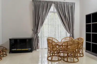 a living room with a table and chairs and a television at Hi-Tea HomeStay in Sungai Petani