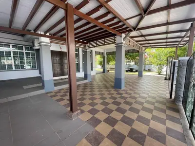an outdoor patio with a wooden roof and a checkered floor at Hi-Tea HomeStay in Sungai Petani