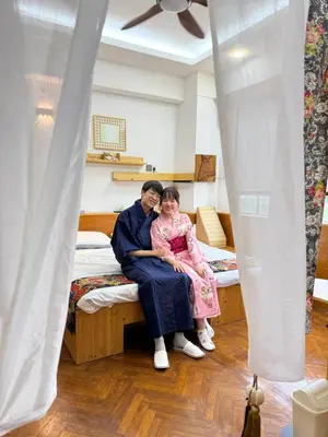 a man and a young girl sitting on a bed at Japan Comfort Lifestyle Hokkaido in Ipoh