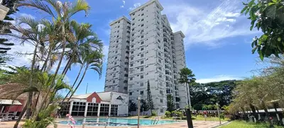 a tall apartment building with a swimming pool and palm trees at Japan Comfort Lifestyle Hokkaido in Ipoh