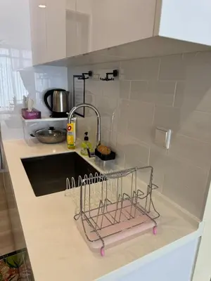 a kitchen counter with a sink and a dish rack at The Floral Retreat N3w Cozy High floor Beacon Executive Suite in George Town