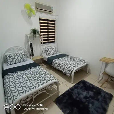 a living room with two beds and a table at MyHomestay Botani in Ipoh