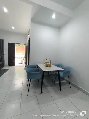 a dining room with a table and blue chairs at Jemput Rezeki Homestay in Bayan Lepas