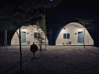 a building with two domes with trees in front of it at Dome Glamping Lojing Highlands in Ladang Pangoi
