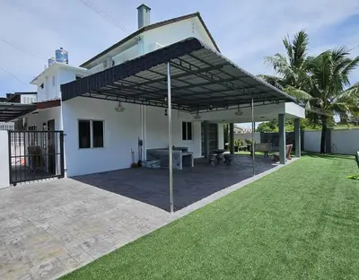 a white house with a patio with awning at Fair Park 2 at Ipoh Town Center in Ipoh