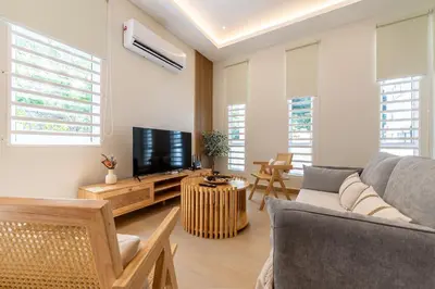 a living room with a couch and a tv at La Ferringhi Villa - Ryokan Collection, by ALV in Batu Ferringhi