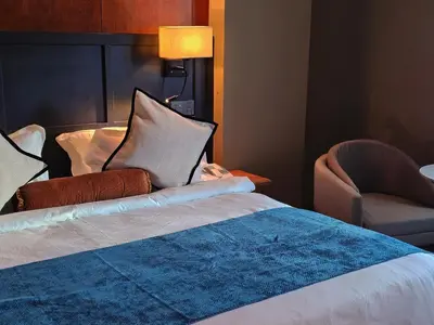 a hotel room with a bed and a chair at Moon Hotel in George Town