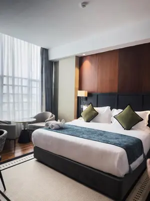 a hotel room with a large bed and a table at Moon Hotel in George Town