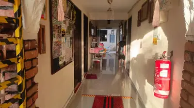 a hallway with a fire extinguisher on the wall at Ali's Guest House in Batu Ferringhi