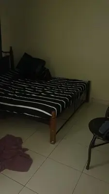 a bed with a black and white comforter in a room at Ali's Guest House in Batu Ferringhi