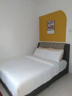 a bed in a room with a yellow headboard at CAMERON LADY ANI Homestay in Tanah Rata