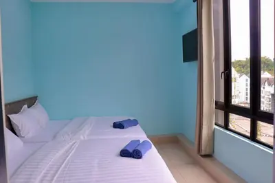 a bedroom with a bed with flip flops and a window at Hotel Aaraa in Brinchang