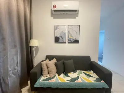 a living room with a couch with a blanket at Ipoh The Anderson 5pax Suite #82 in Ipoh