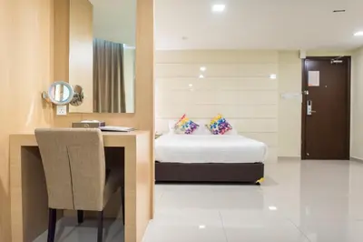 a room with a bed and a desk and a mirror at Mornington Hotel Sitiawan in Sitiawan
