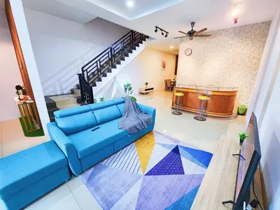 a living room with a blue couch and a staircase at 30 Bercham Double-Storey Homestay in Ipoh