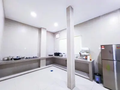 a large kitchen with a counter and a refrigerator at 30 Bercham Double-Storey Homestay in Ipoh
