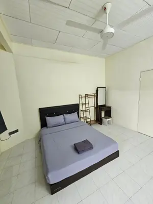 a bedroom with a bed in a white room at May Flower Hostel in Ipoh