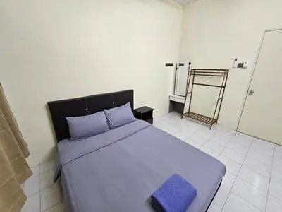 a bedroom with a large bed with a blue blanket at May Flower Hostel in Ipoh