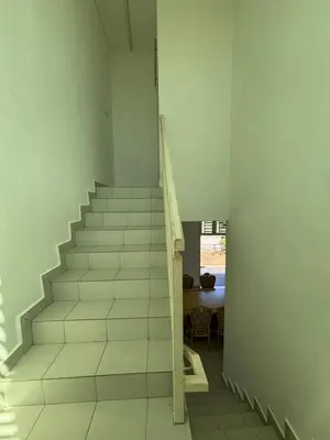 a staircase in a room with a table at MDRS Seroja 6 in Kuala Ketil
