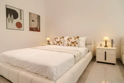 a white bedroom with a white bed and two lamps at Georgetown Bright & Kid-Friendly KTV 3BR 15pax C in George Town