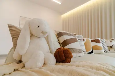 a white stuffed animal sitting on top of a bed at Georgetown Bright & Kid-Friendly KTV 3BR 15pax C in George Town